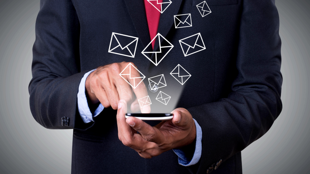 A man in suit holding a mobile phone with multiple SMS icons coming out of it