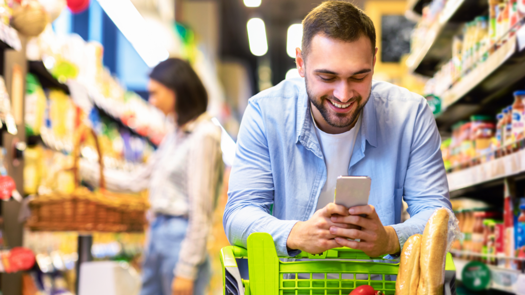 An person looking at a mobile phone while shopping inside a grocery